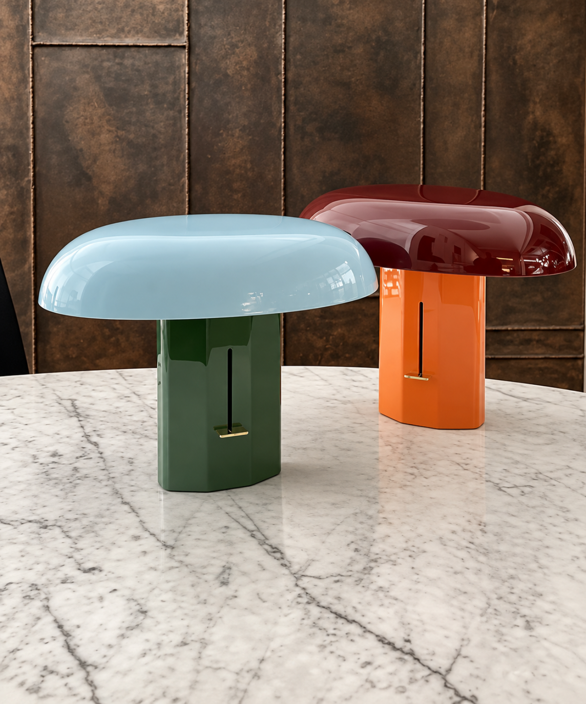 Deux lampes champignon, bleu et vert puis rouge et orange, posées sur une table en marbre