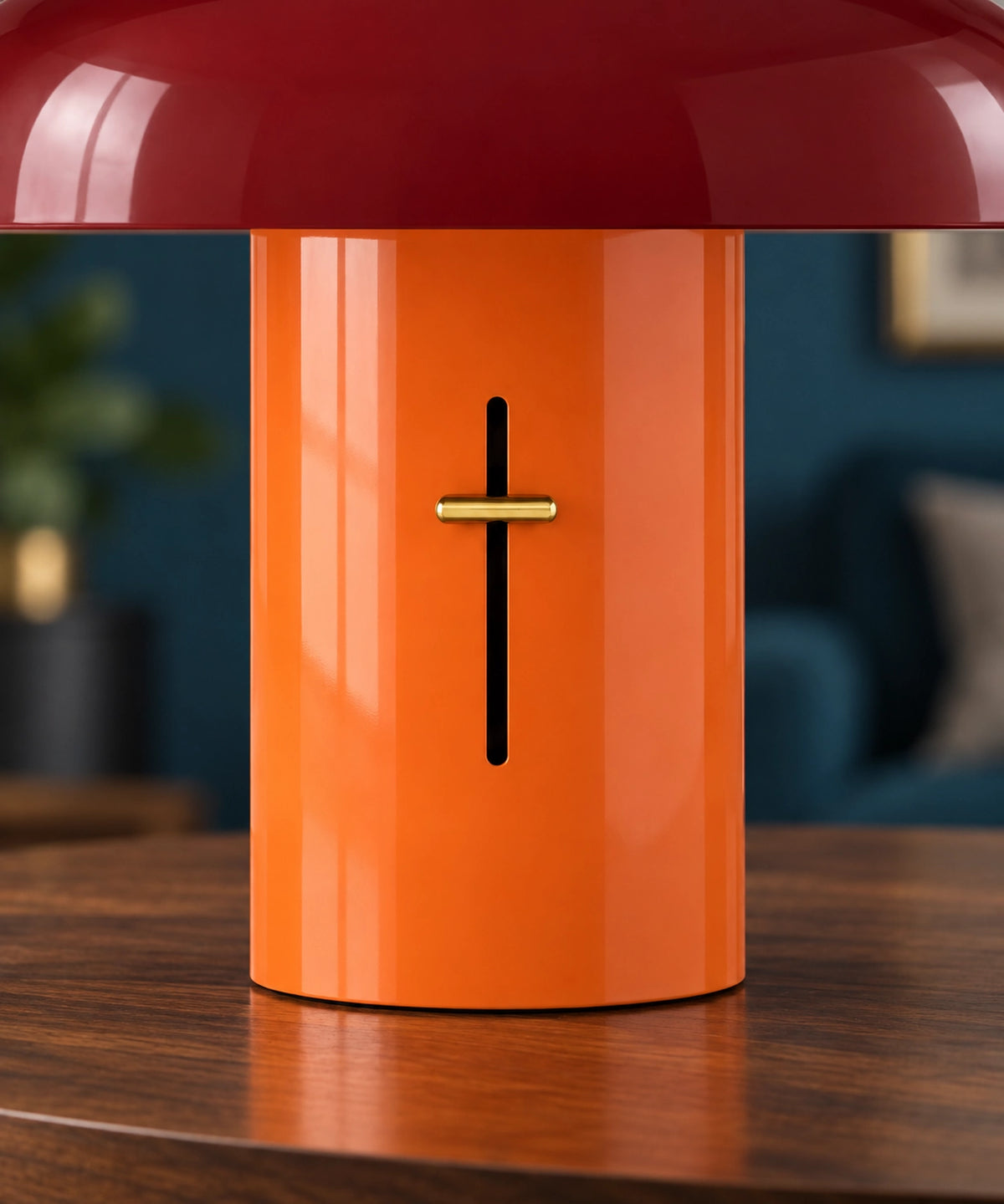 Gros plan du pied orange, de la commande dorée et de l’abat-jour rouge d’une lampe champignon