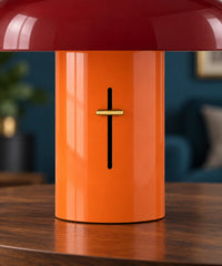 Gros plan du pied orange, de la commande dorée et de l’abat-jour rouge d’une lampe champignon