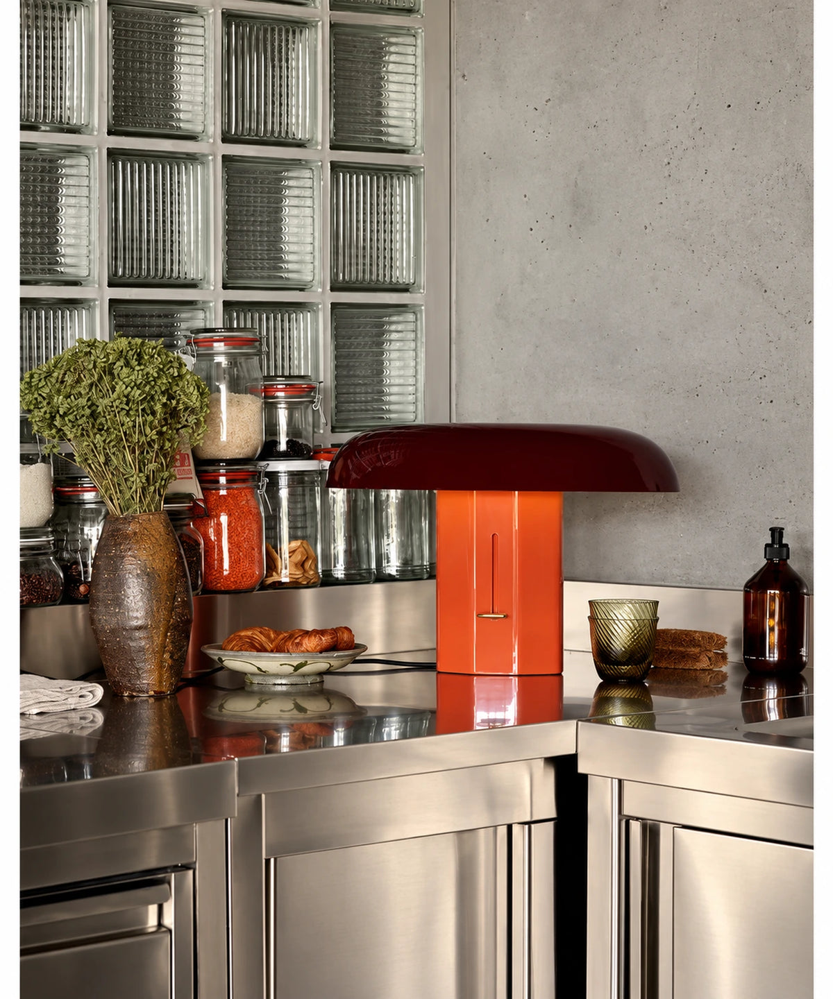 Lampe champignon rouge et orange sur un plan de travail de cuisine en métal