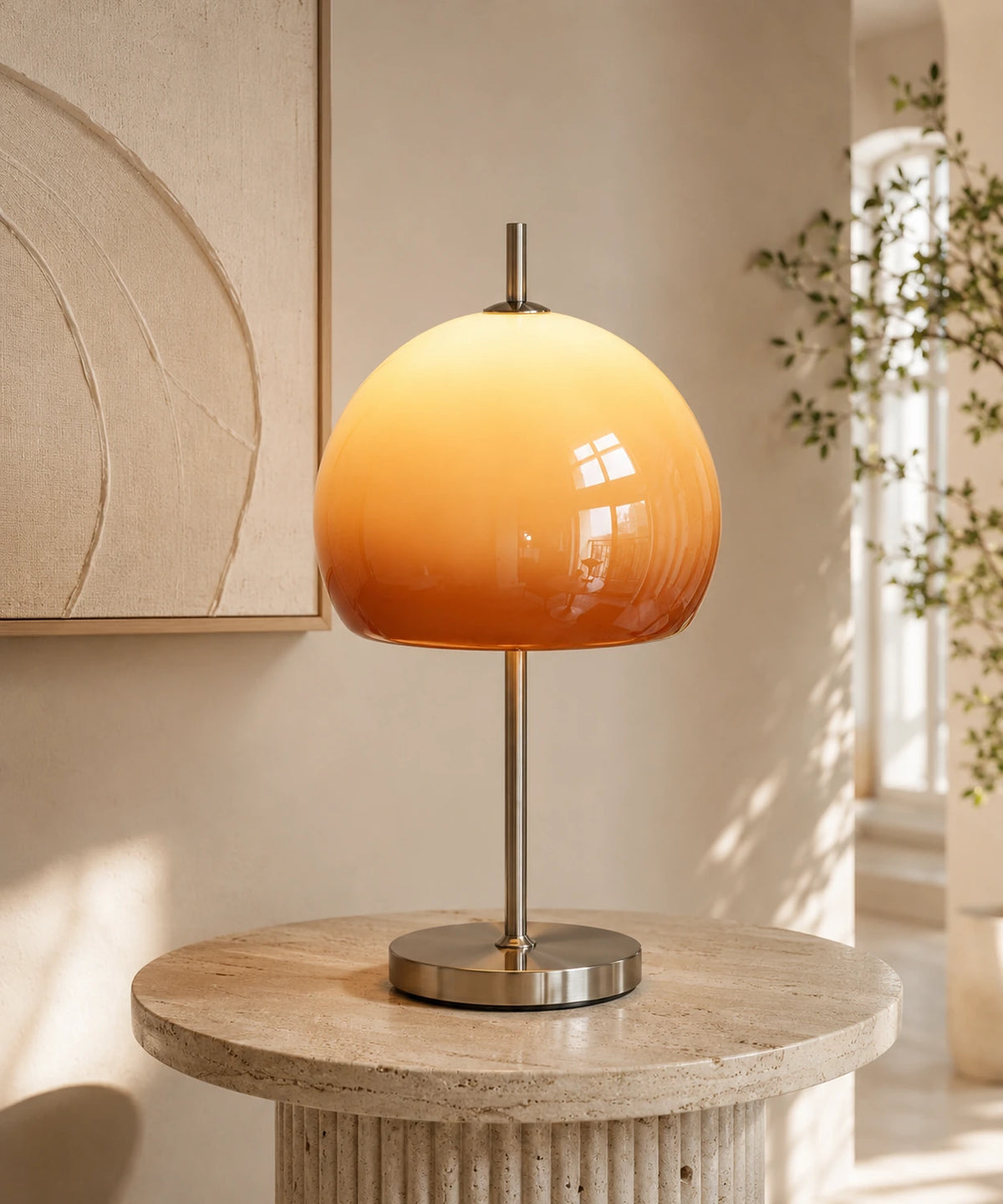 Lampe champignon orange vintage en verre dégradé posée sur une table en travertin, allumée