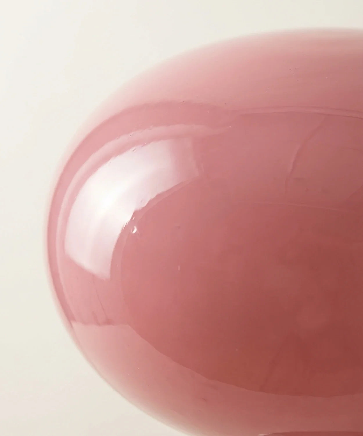 Gros plan sur le verre soufflé rose poudré du galet, surface lisse et brillante Image