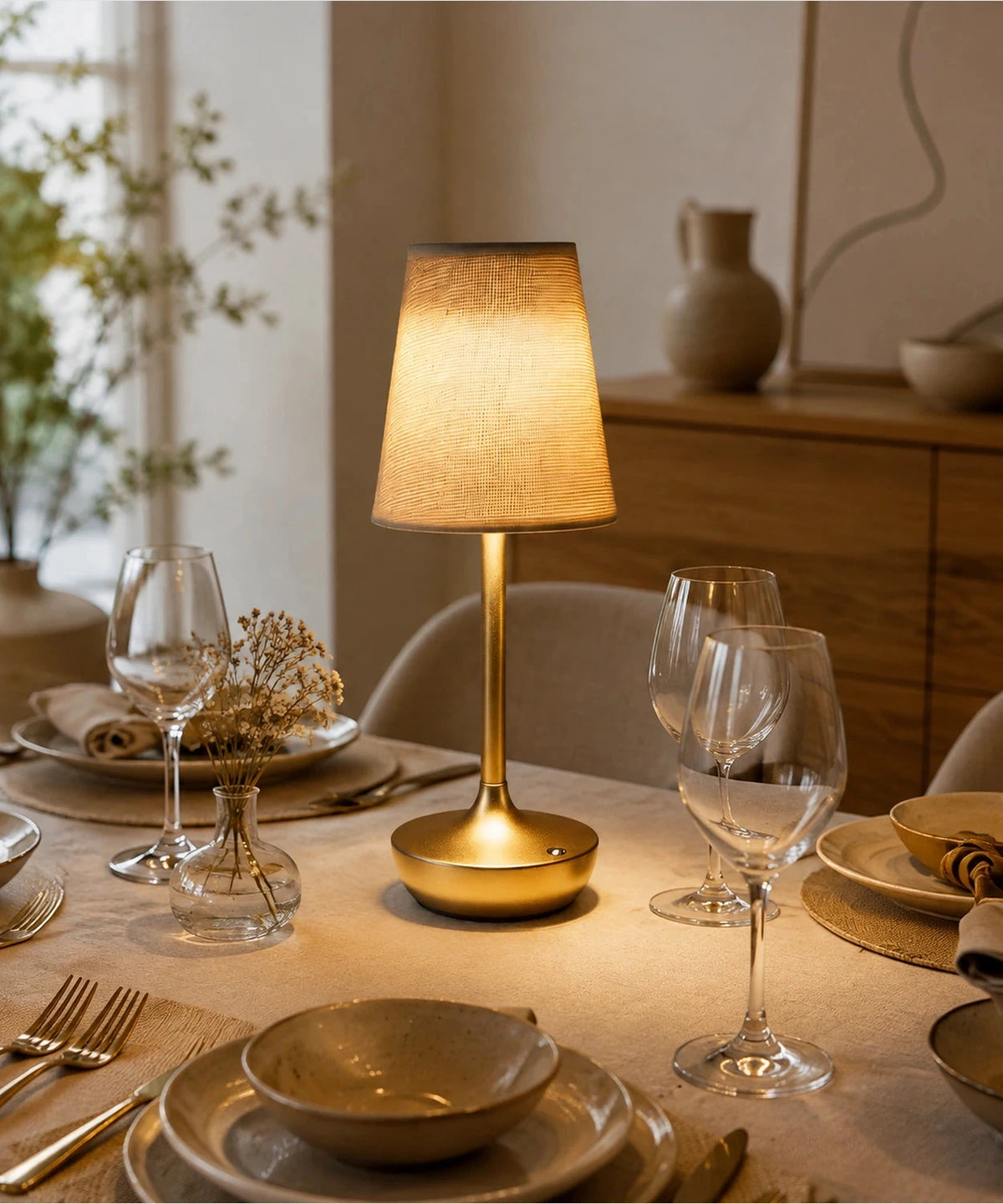Lampe de table dorée à abat-jour en tissu, sur une table dressée Image