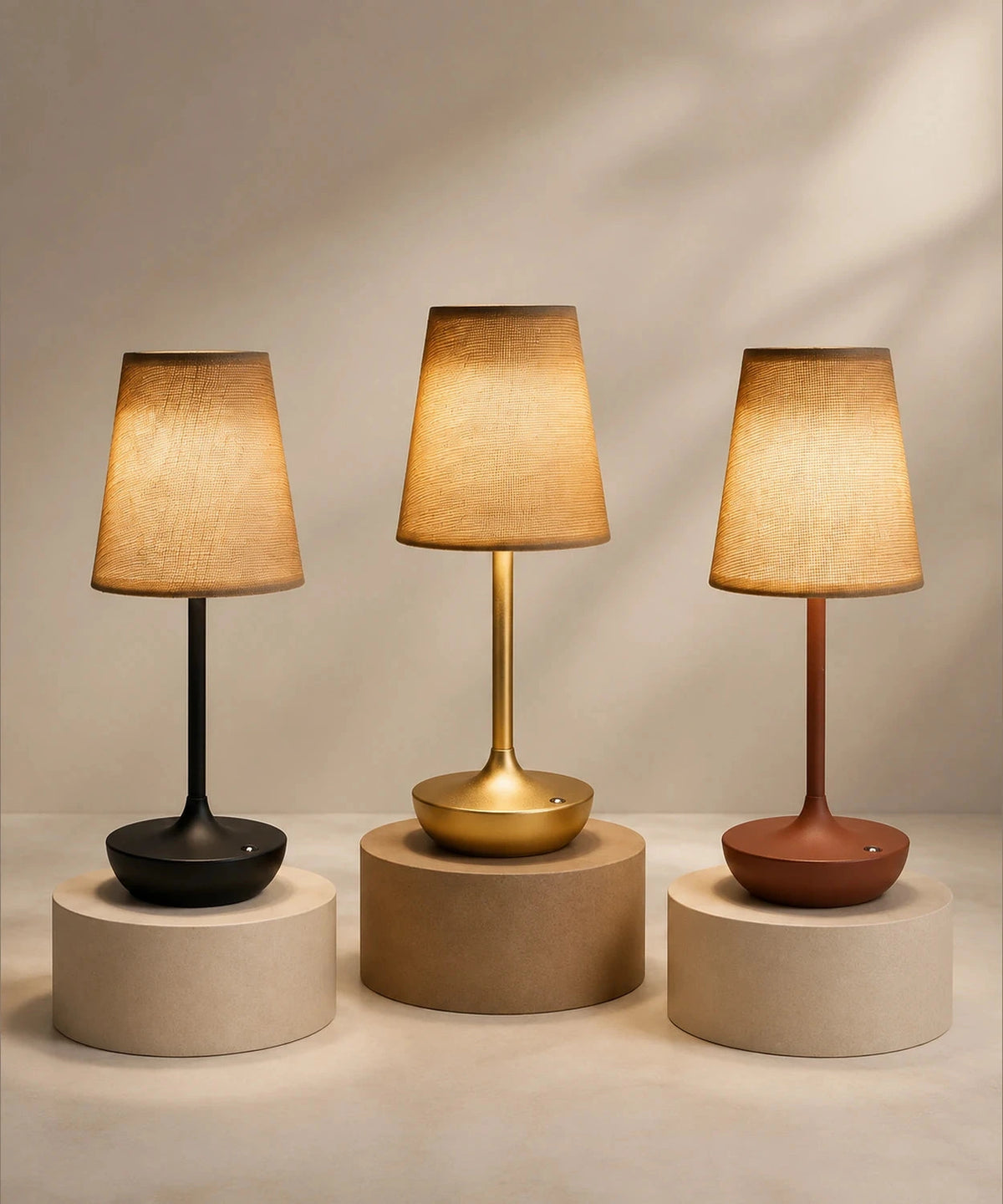 Trois lampes de table sans fil en tissu, finitions noire, dorée et marron