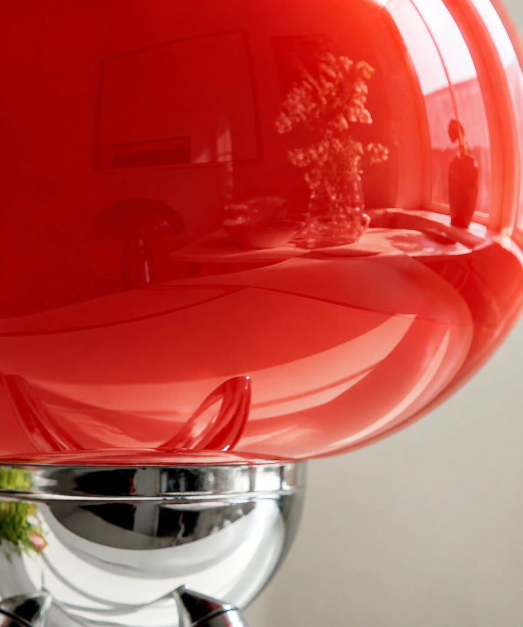 Détail du verre rouge brillant et de la coupelle chromée de la lampe de table sans fil