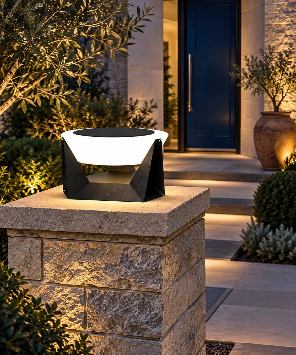Lampe solaire à vasque ronde sur un pilier près d’une entrée de jardin
