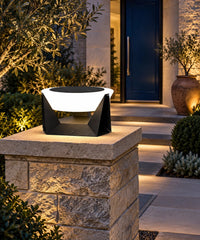 Lampe solaire à vasque ronde sur un pilier près d’une entrée de jardin