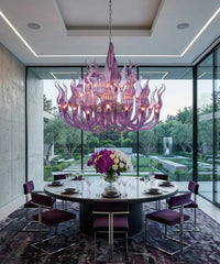 Lustre à bras en cristal violet au-dessus d’une table ronde, baie vitrée sur le jardin
