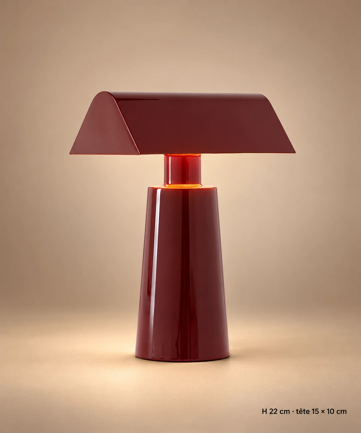 Lampe de table en métal bordeaux sur fond brun-beige, avec hauteur de 22 cm et tête de 15 × 10 cm
