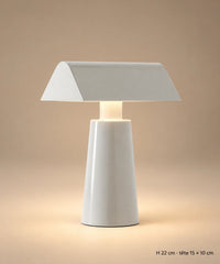 Lampe de table en métal gris clair sur fond brun-beige, avec hauteur de 22 cm et tête de 15 × 10 cm