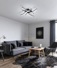 Plafonnier noir à quatre barres courbes dans un salon aux tons gris