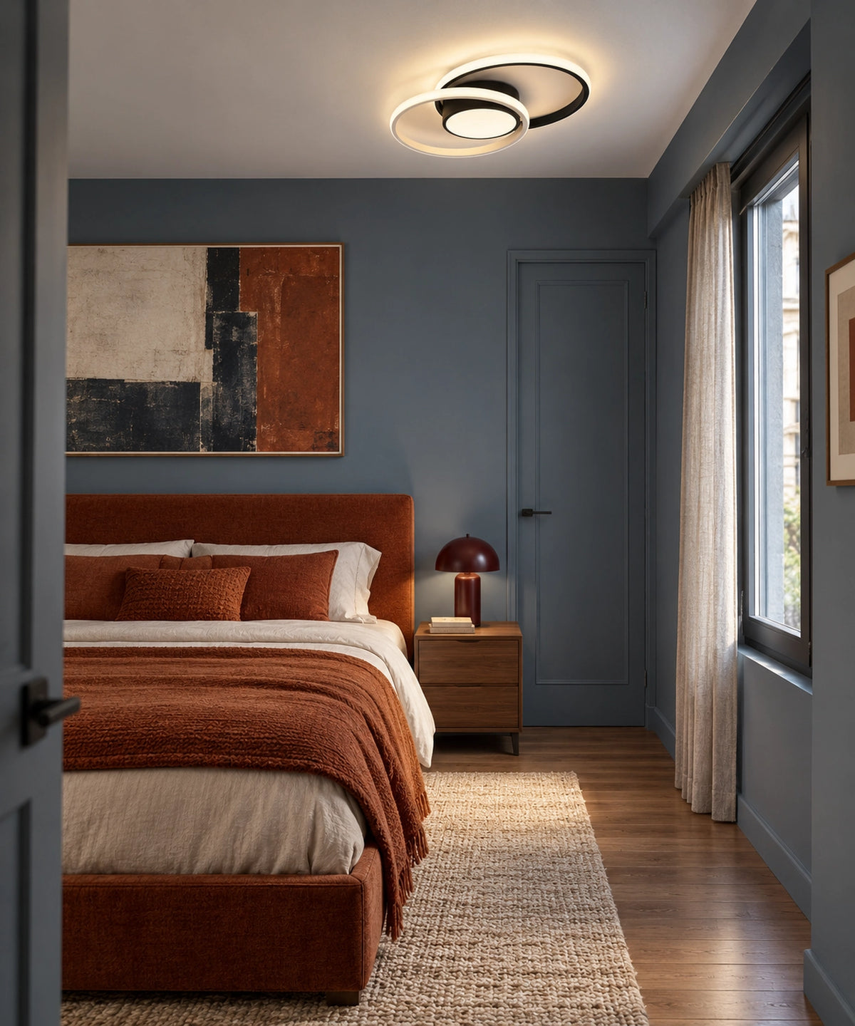 Plafonnier à deux anneaux noirs dans une chambre aux tons bleus et rouille
