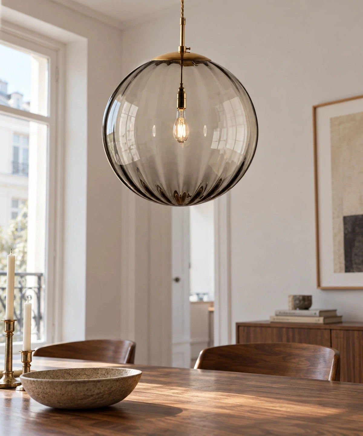 Suspension boule en verre fumé clair côtelé au-dessus d’une table