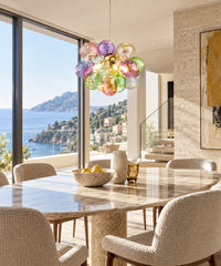 Suspension à 24 bulles en verre multicolore au-dessus d’une table face à la mer