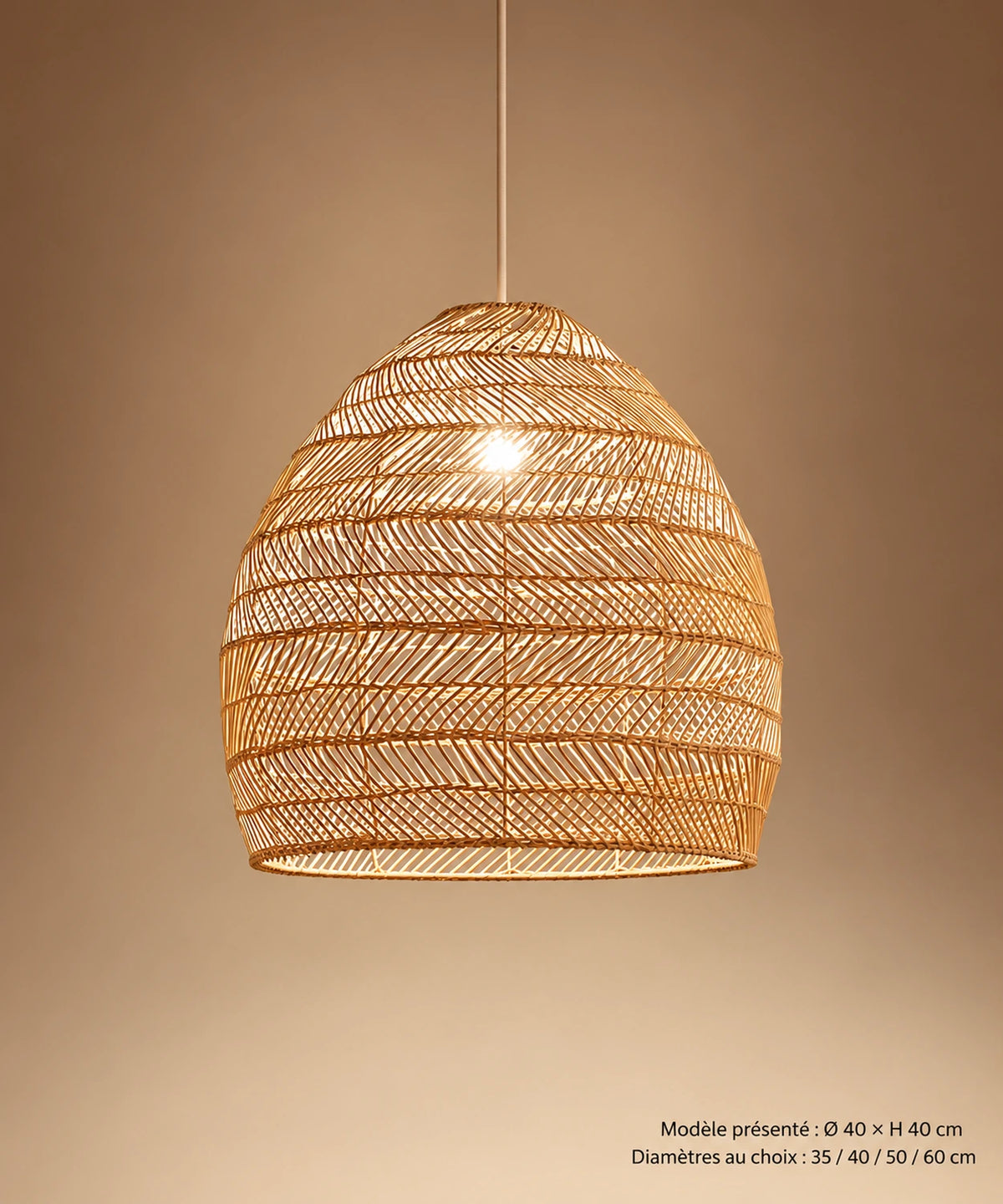 Suspension cloche en rotin beige avec câble visible, sur fond brun-beige dégradé