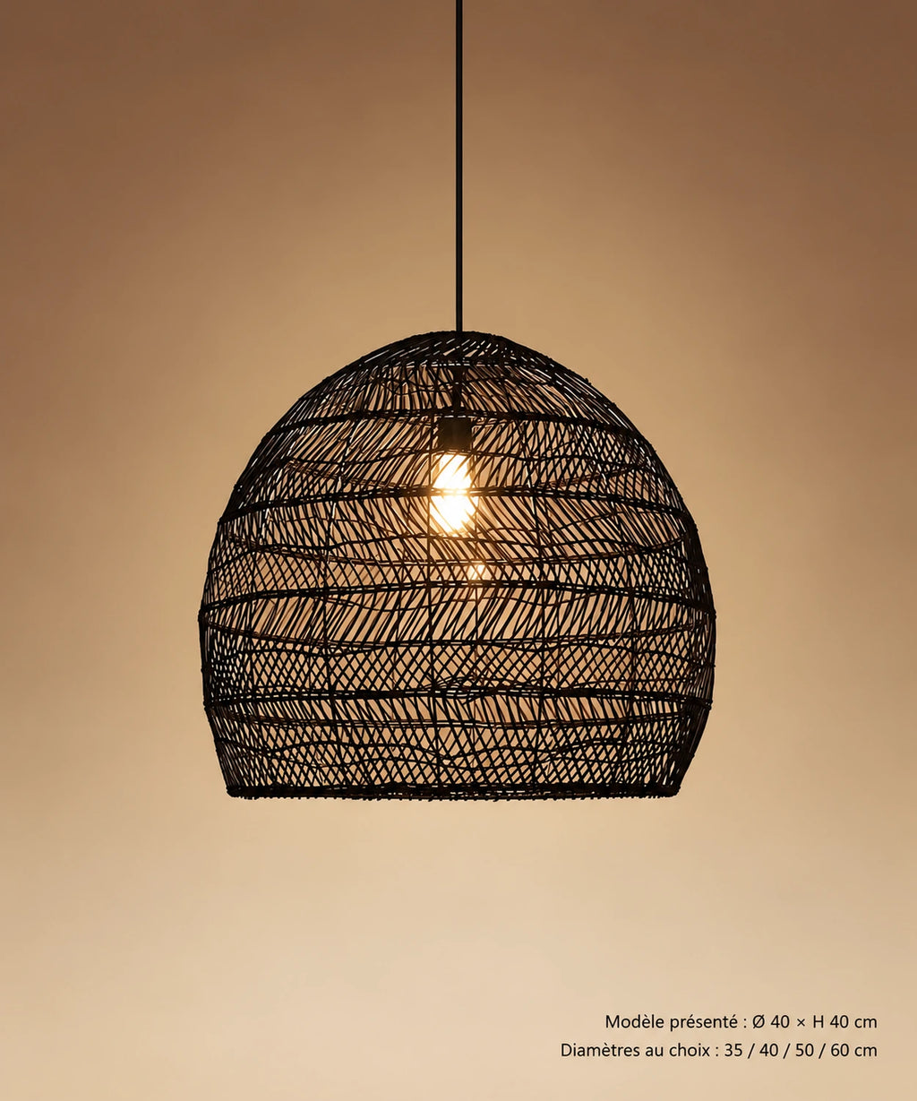 Suspension cloche en rotin noir avec câble visible, sur fond brun-beige dégradé