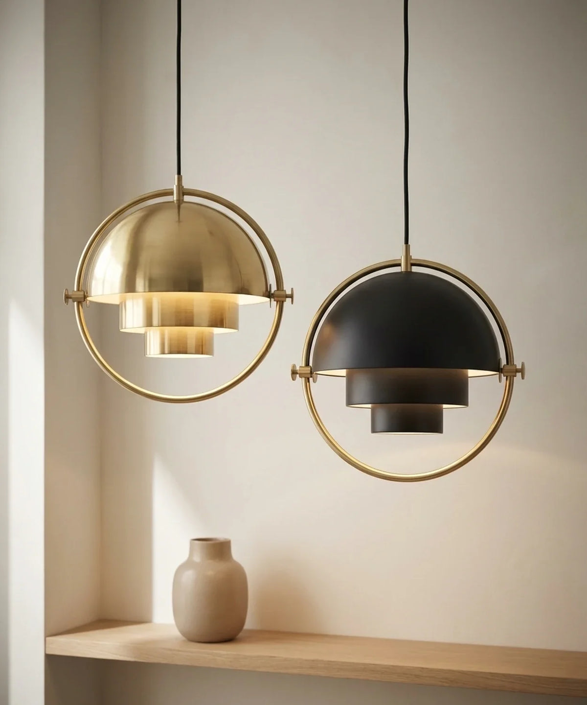 Deux suspensions demi sphere orientable, une laiton et une noire, allumees cote a cote
