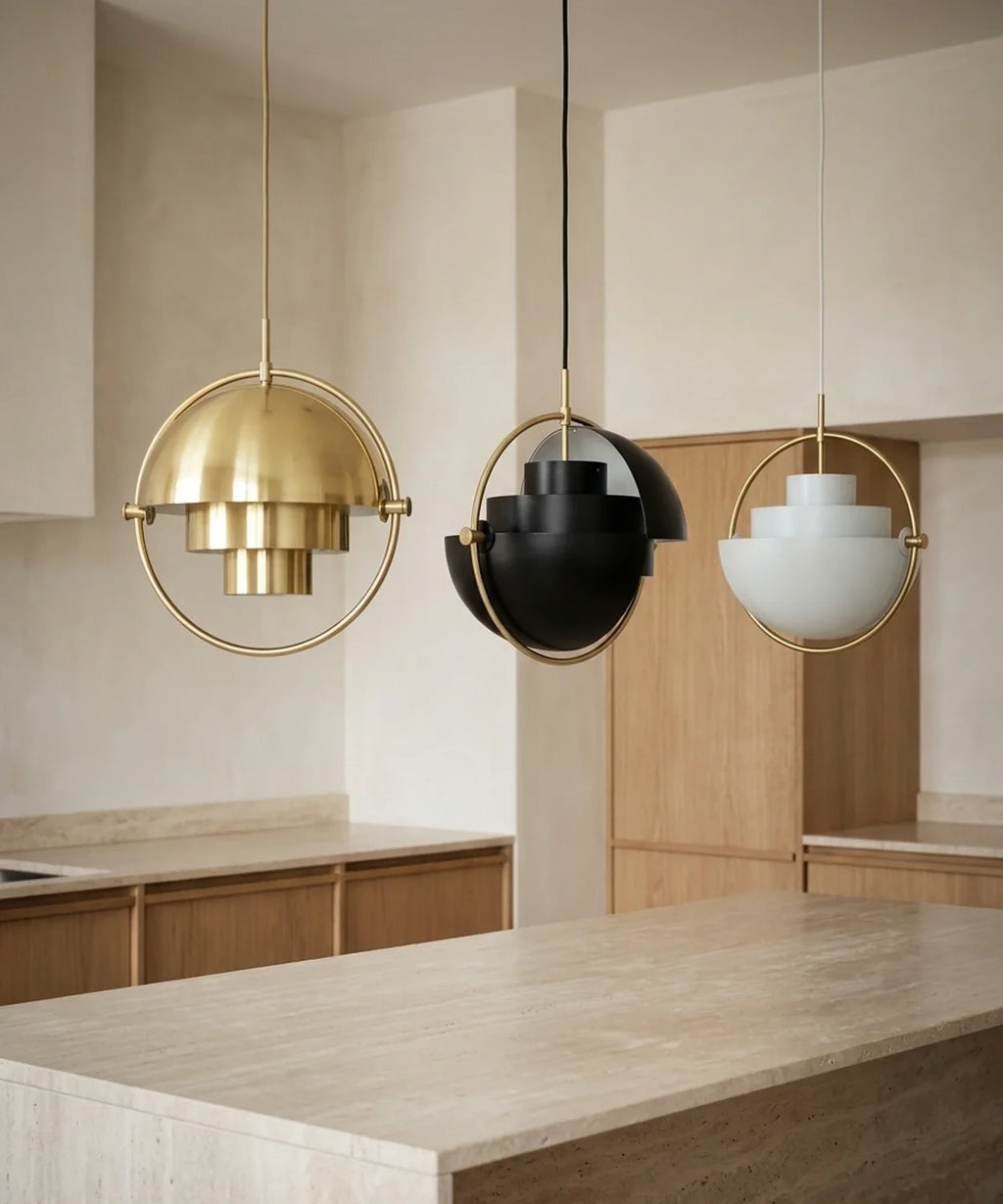 Trois suspensions demi sphère orientable laiton, noir et blanc au-dessus d un îlot de cuisine