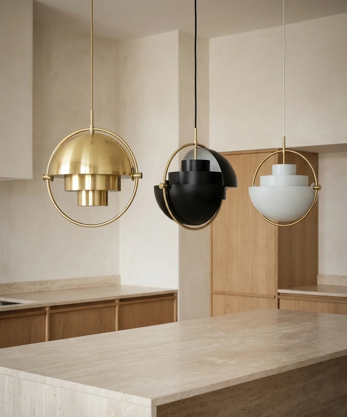 Trois suspensions demi sphère orientable laiton, noir et blanc au-dessus d un îlot de cuisine