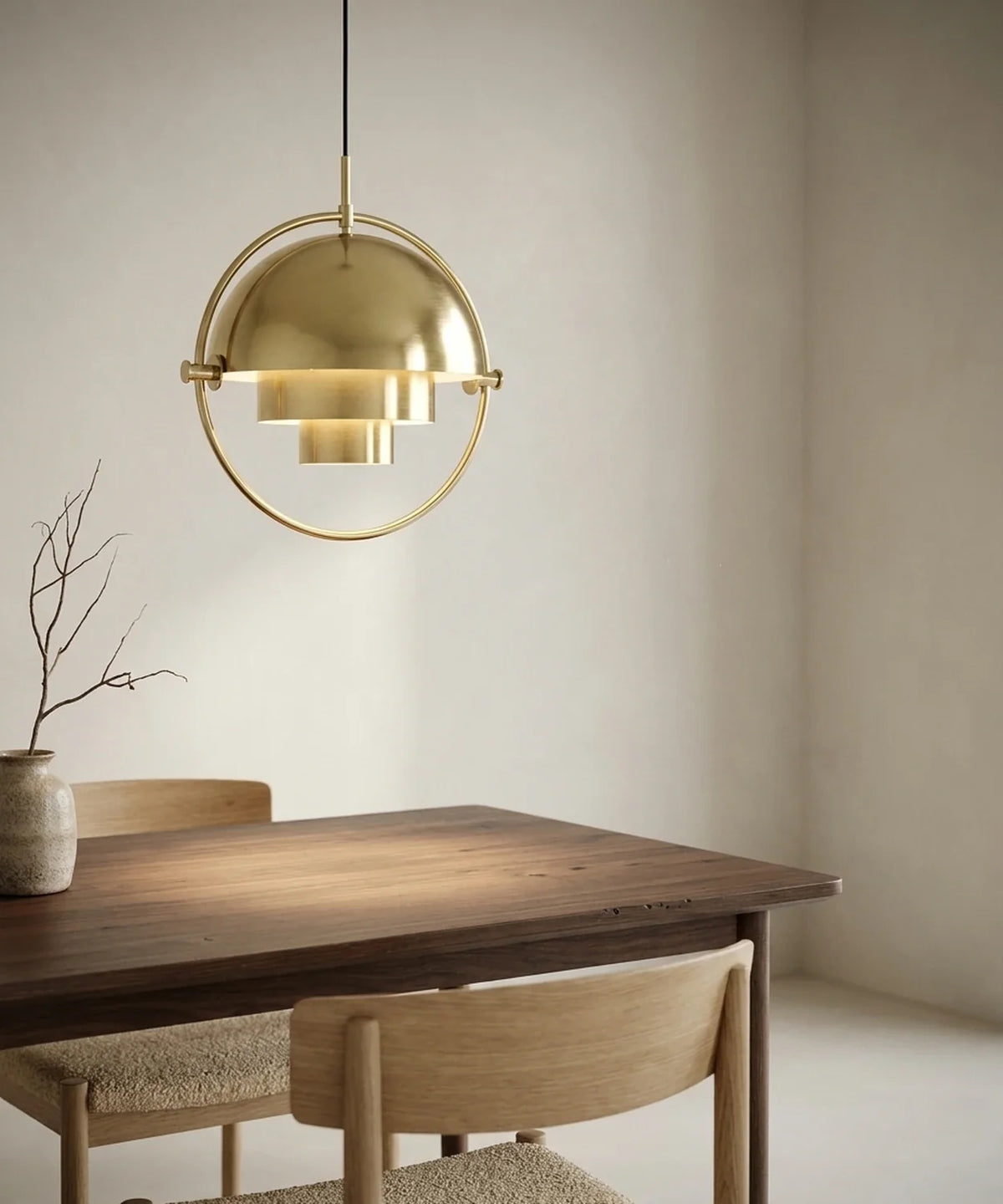 Suspension demi sphère orientable en laiton allumée au-dessus d une table en noyer
