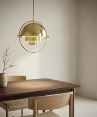 Suspension demi sphère orientable en laiton allumée au-dessus d une table en noyer