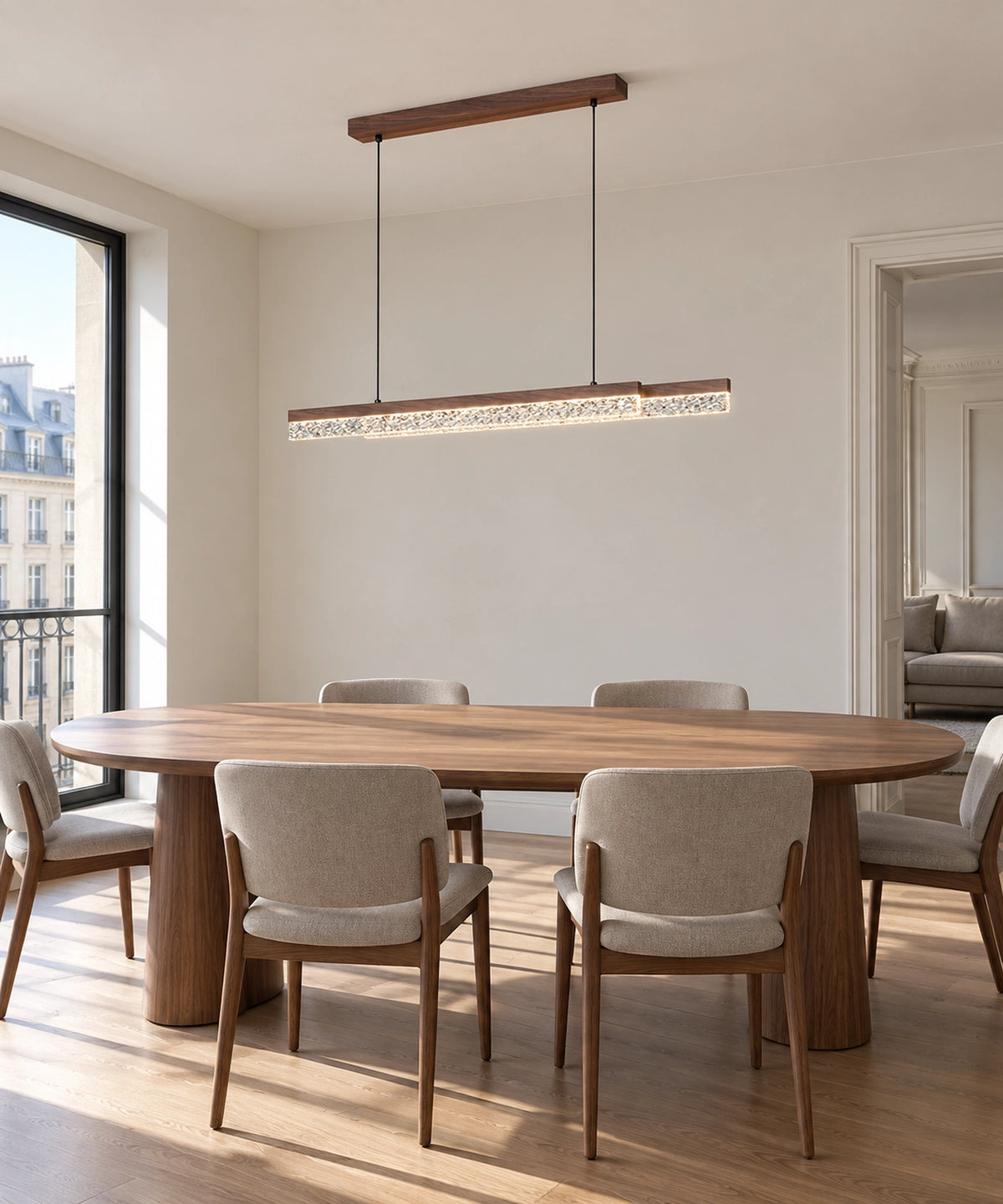Suspension LED marron aspect bois au-dessus d’une table ovale entourée de chaises claires