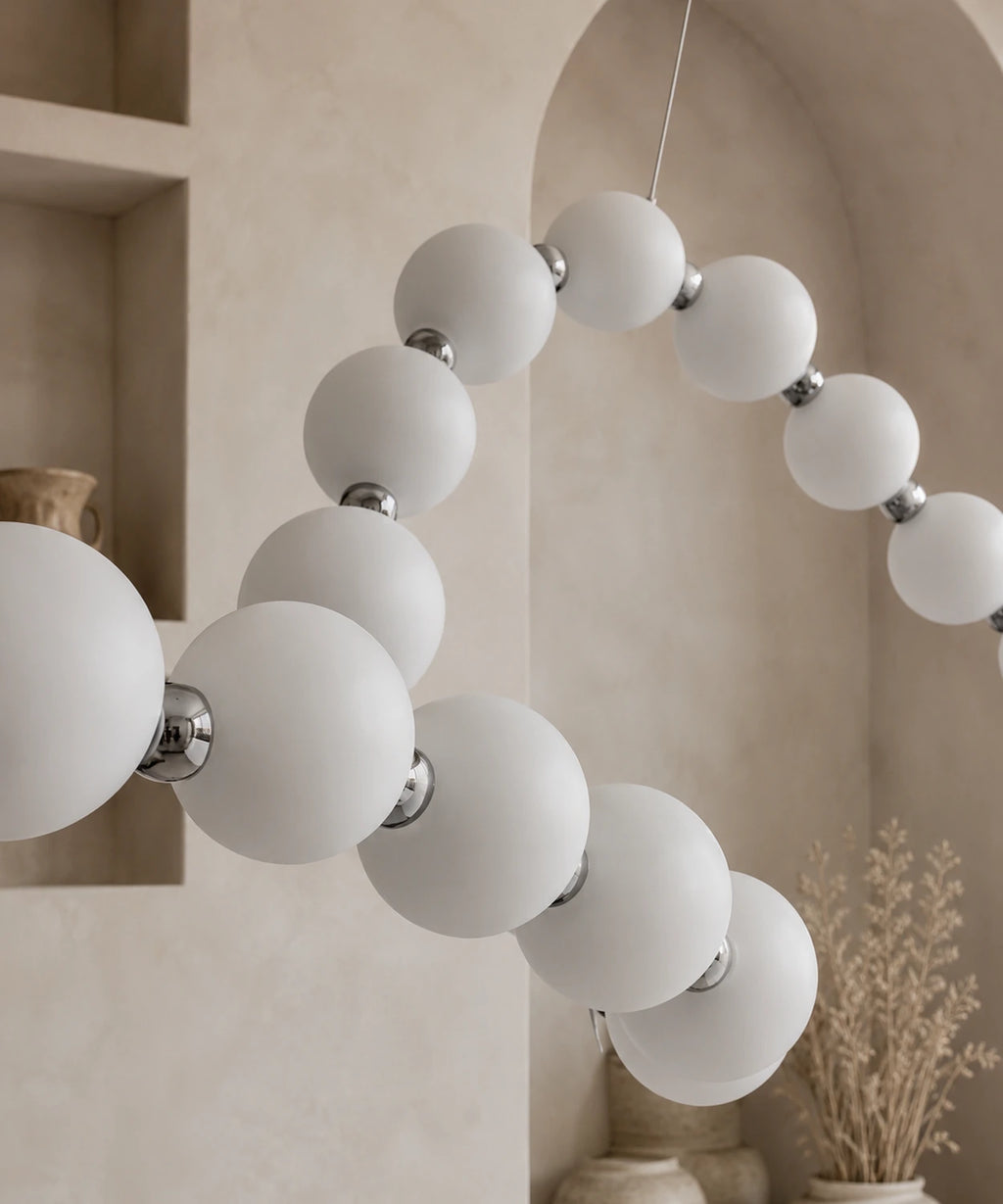 Détail des globes opalins et des connecteurs chromés de la guirlande de boules