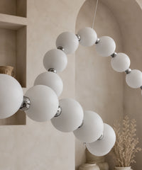 Détail des globes opalins et des connecteurs chromés de la guirlande de boules