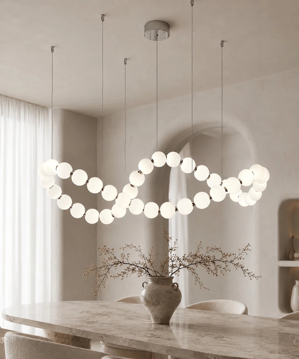 Suspension luminaire boules allumée, vague de globes au-dessus d’une table et d’un vase