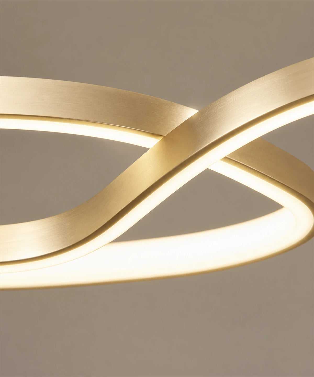 Détail du point où le ruban doré de la suspension LED se croise, bande opaline allumée