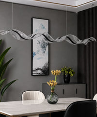 Suspension luminaire LED vague à ruban blanc au-dessus d’une table, mur gris et tableau