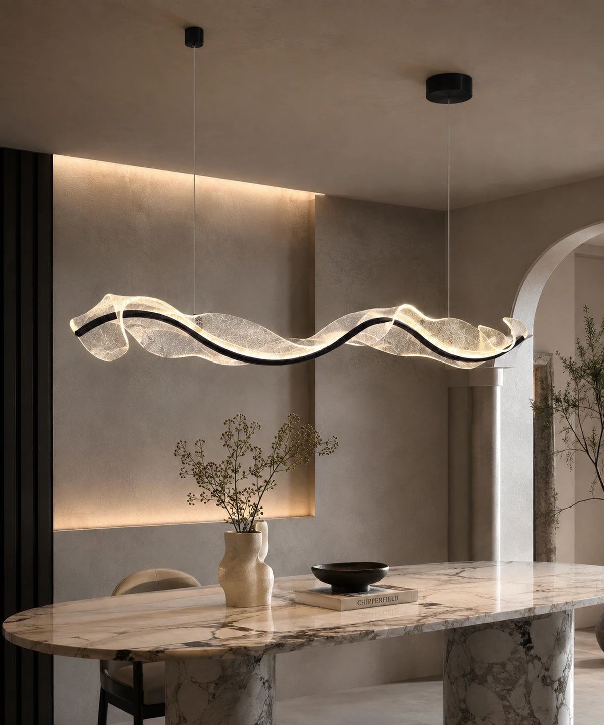 Suspension luminaire LED vague à ruban noir allumée au-dessus d’une table en marbre