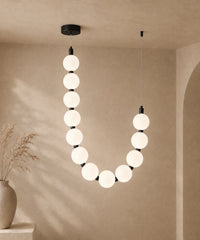 Suspension luminaire perles à un brin, connecteurs noirs, allumée