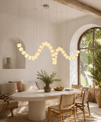 Suspension luminaire plusieurs boules au-dessus d’une table ronde et de chaises en rotin