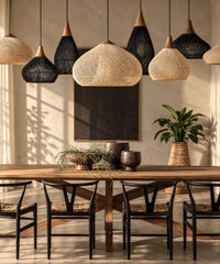 Suspensions en rotin et bois, formes et finitions naturelles et noires réunies au-dessus d’une table