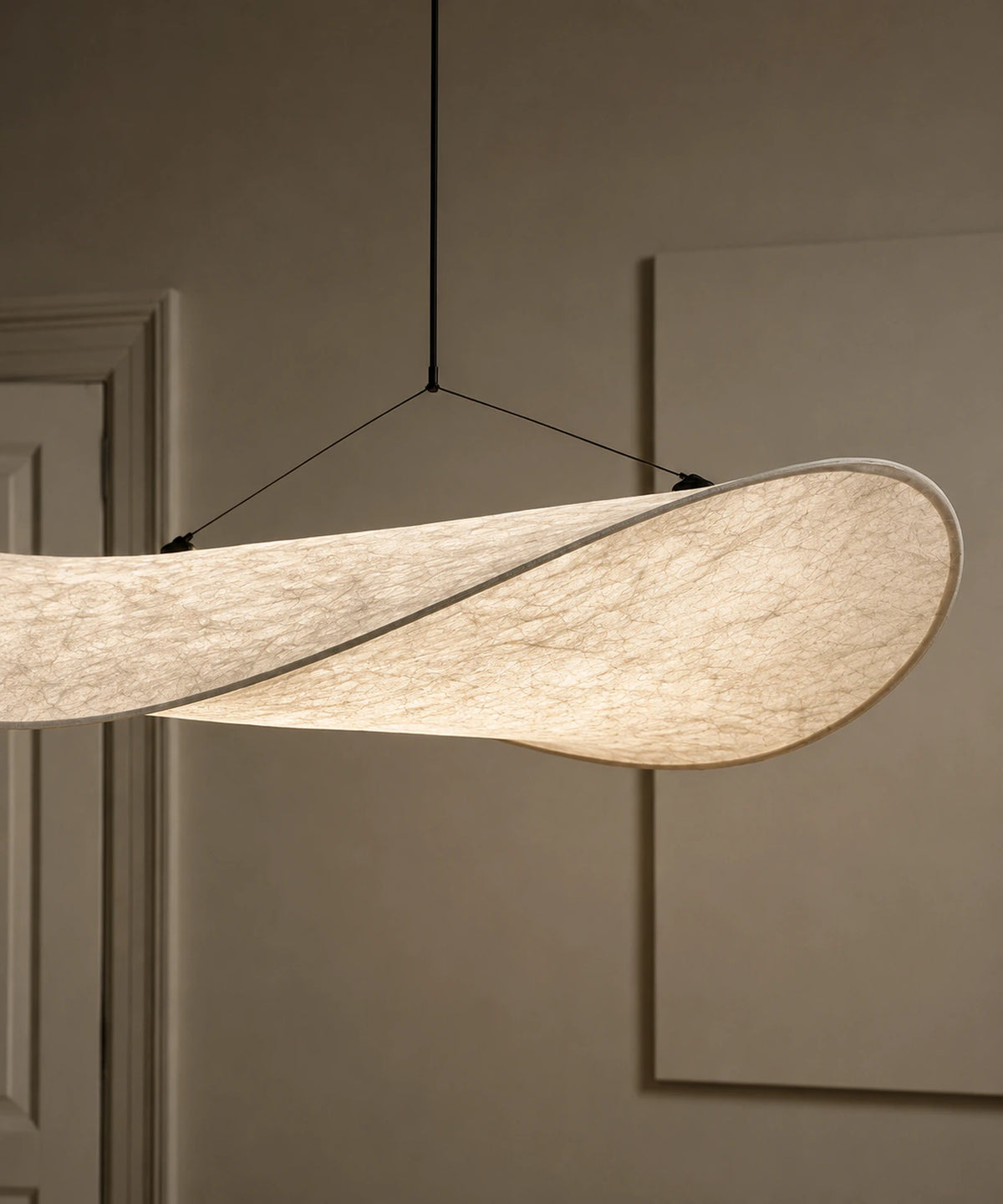 Détail de la toile blanche tendue sur l’armature courbe et des câbles de la suspension