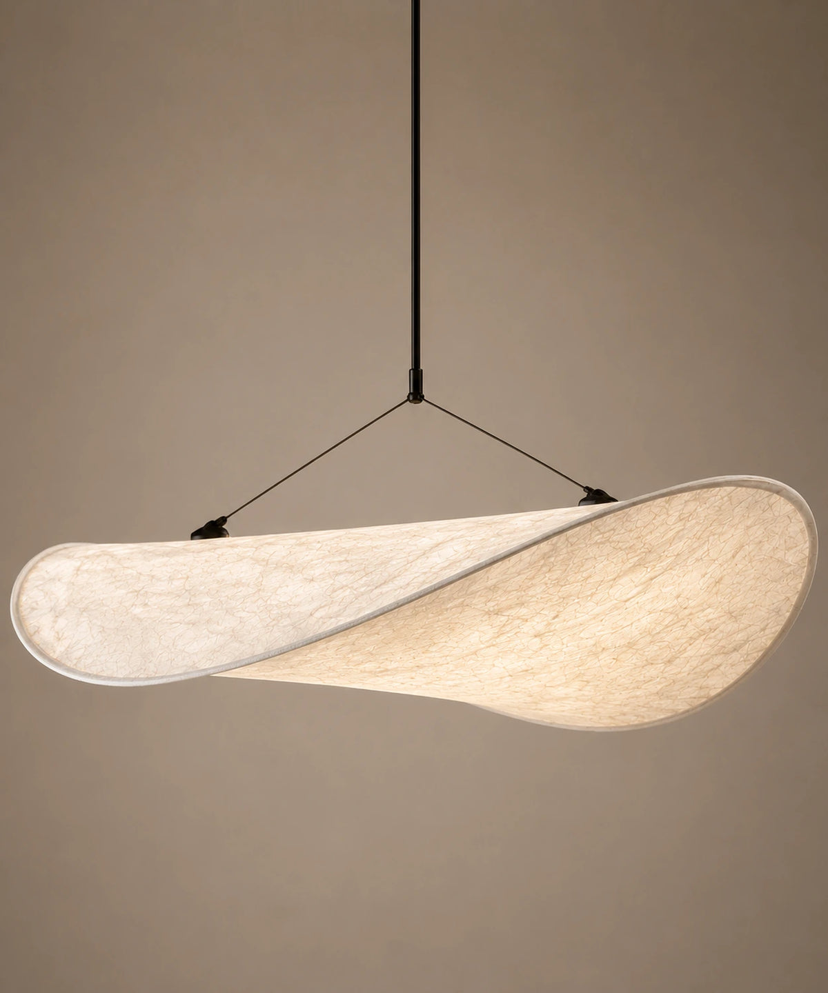 Suspension luminaire tissu blanc tendu comme une voile, câbles fins et rosace, sur fond beige