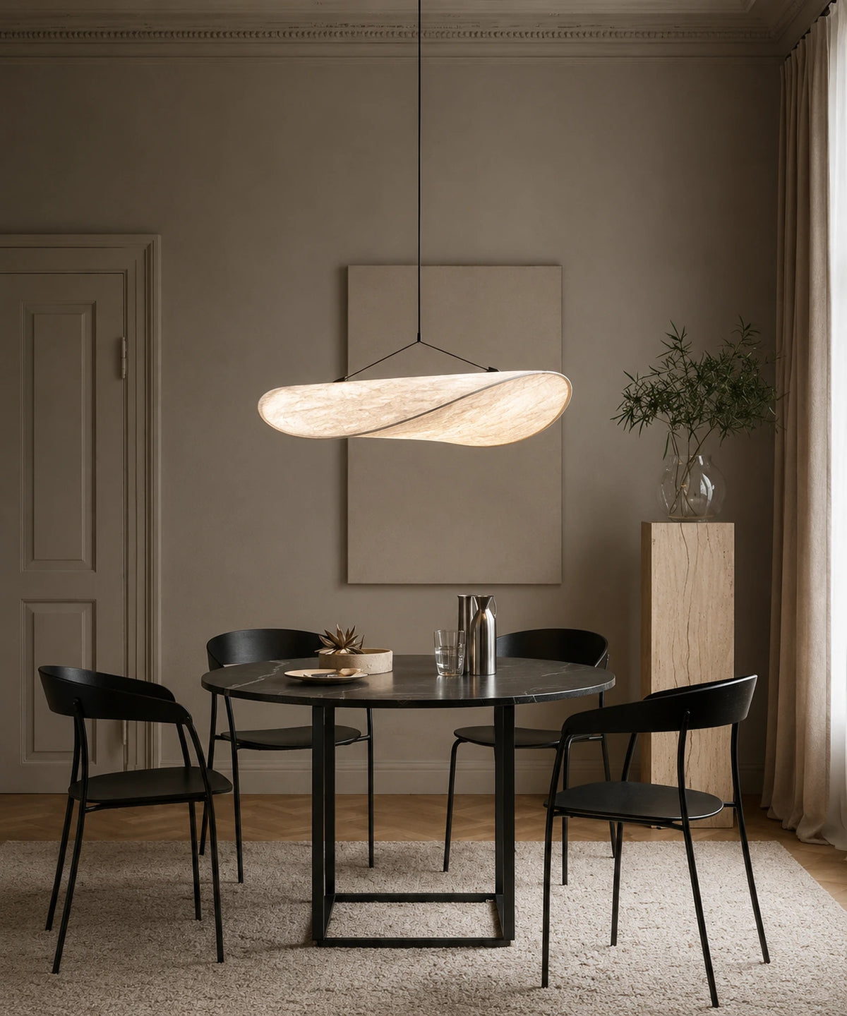 Suspension en tissu blanc de 80 cm allumée au-dessus d’une table ronde et de chaises noires
