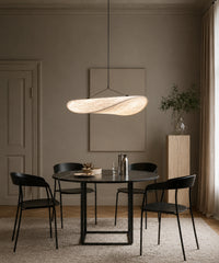 Suspension en tissu blanc de 80 cm allumée au-dessus d’une table ronde et de chaises noires