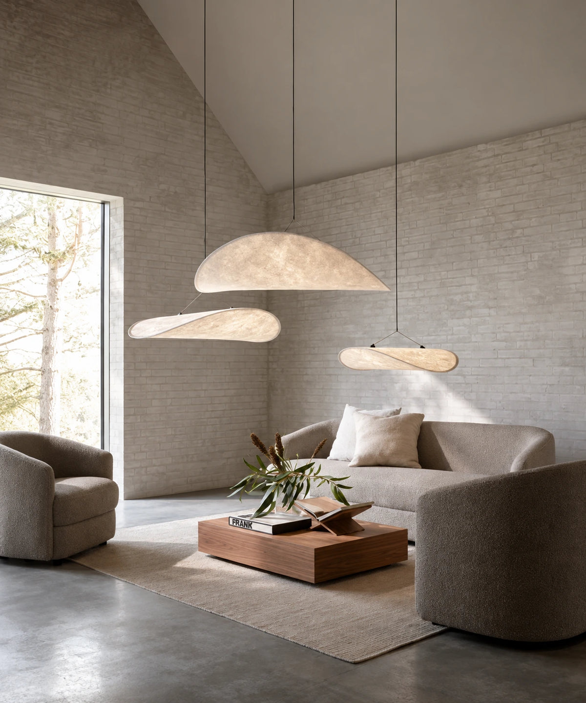Suspensions luminaire tissu blanc en voile dans un salon aux murs de briques peintes