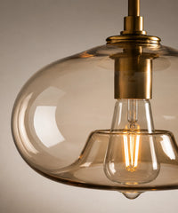 Détail de la monture en laiton antique et du verre champagne autour de l’ampoule