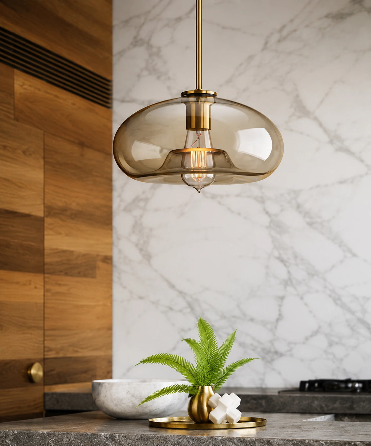 Suspension luminaire verre champagne en galet devant une crédence en marbre et un mur de bois Image