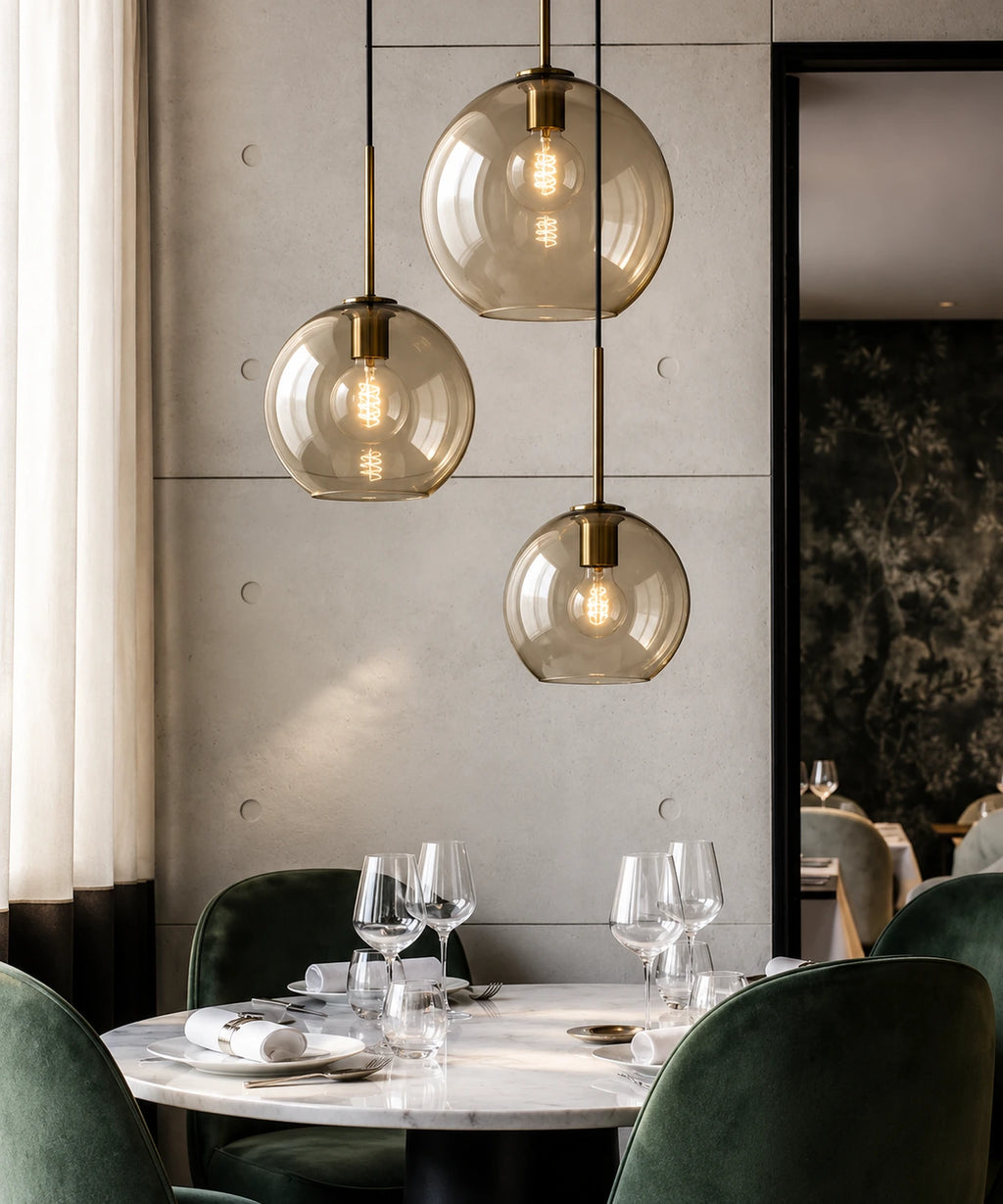 Grappe de suspensions en verre champagne et laiton au-dessus d’une table dressée