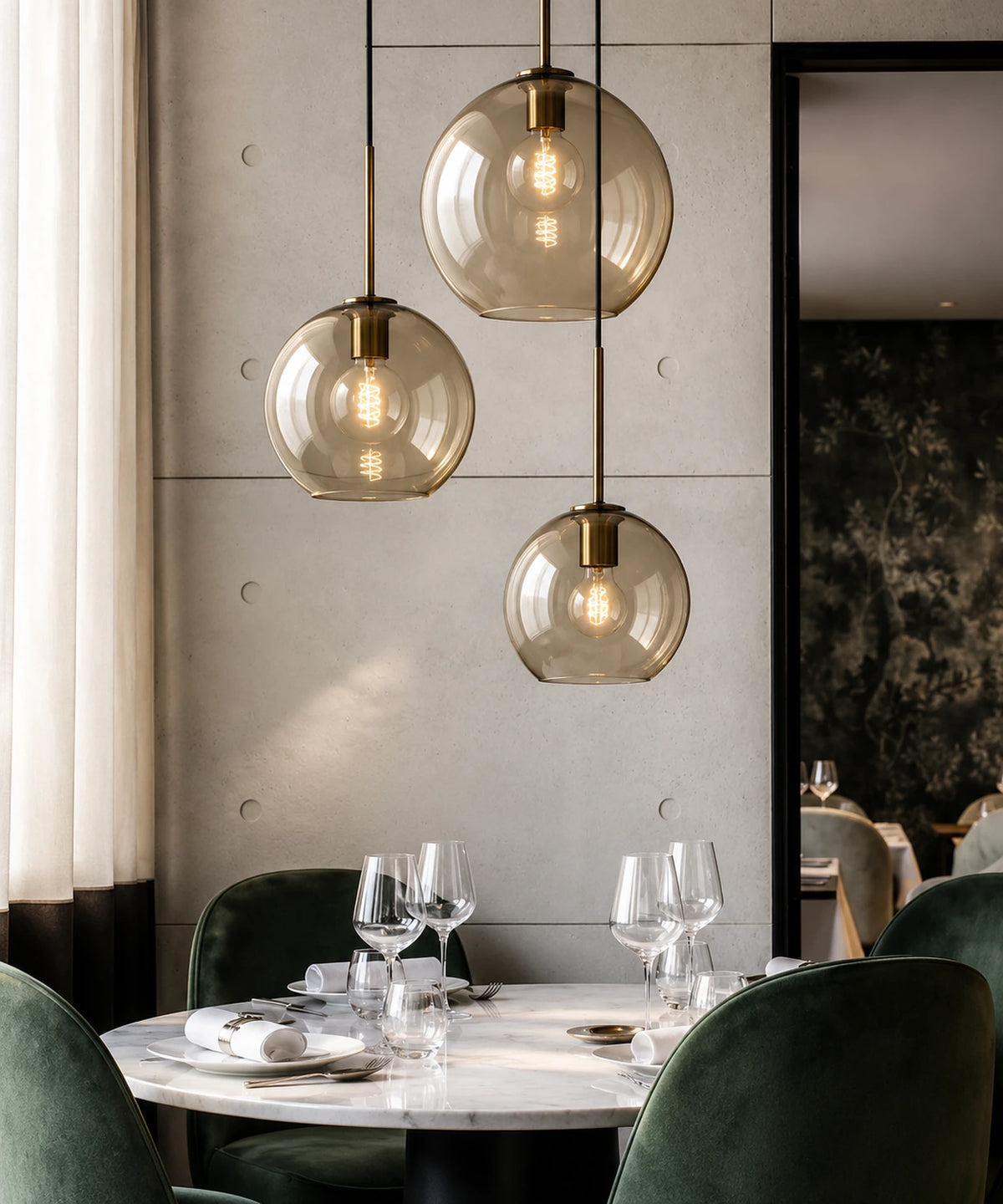 Grappe de suspensions en verre champagne et laiton au-dessus d’une table dressée