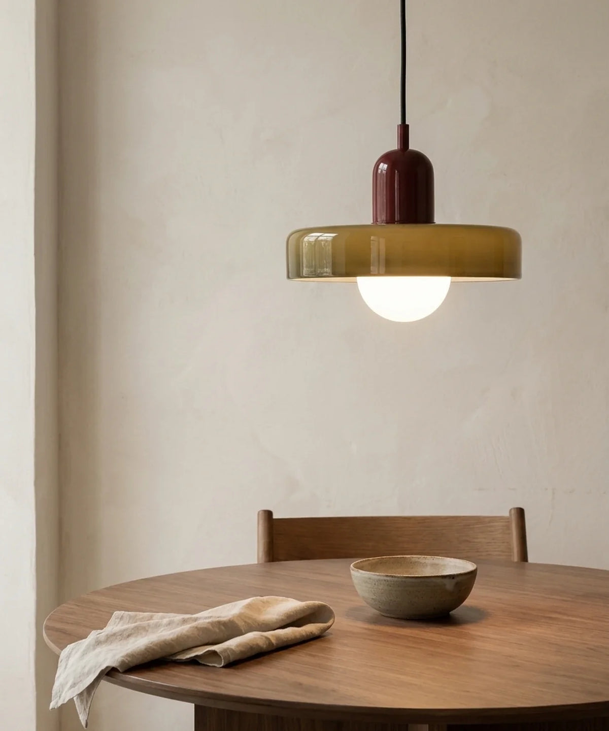 Suspension en verre coloré vert olive allumée à 70 cm au-dessus d’une table ronde