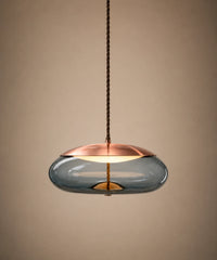 Suspension galet en verre soufflé bleu, capuchon cuivré, allumée sur fond beige