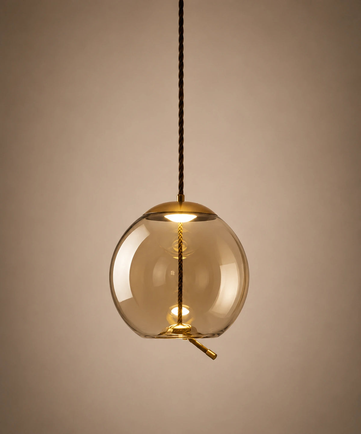 Suspension boule en verre soufflé cognac traversée d’une corde tressée