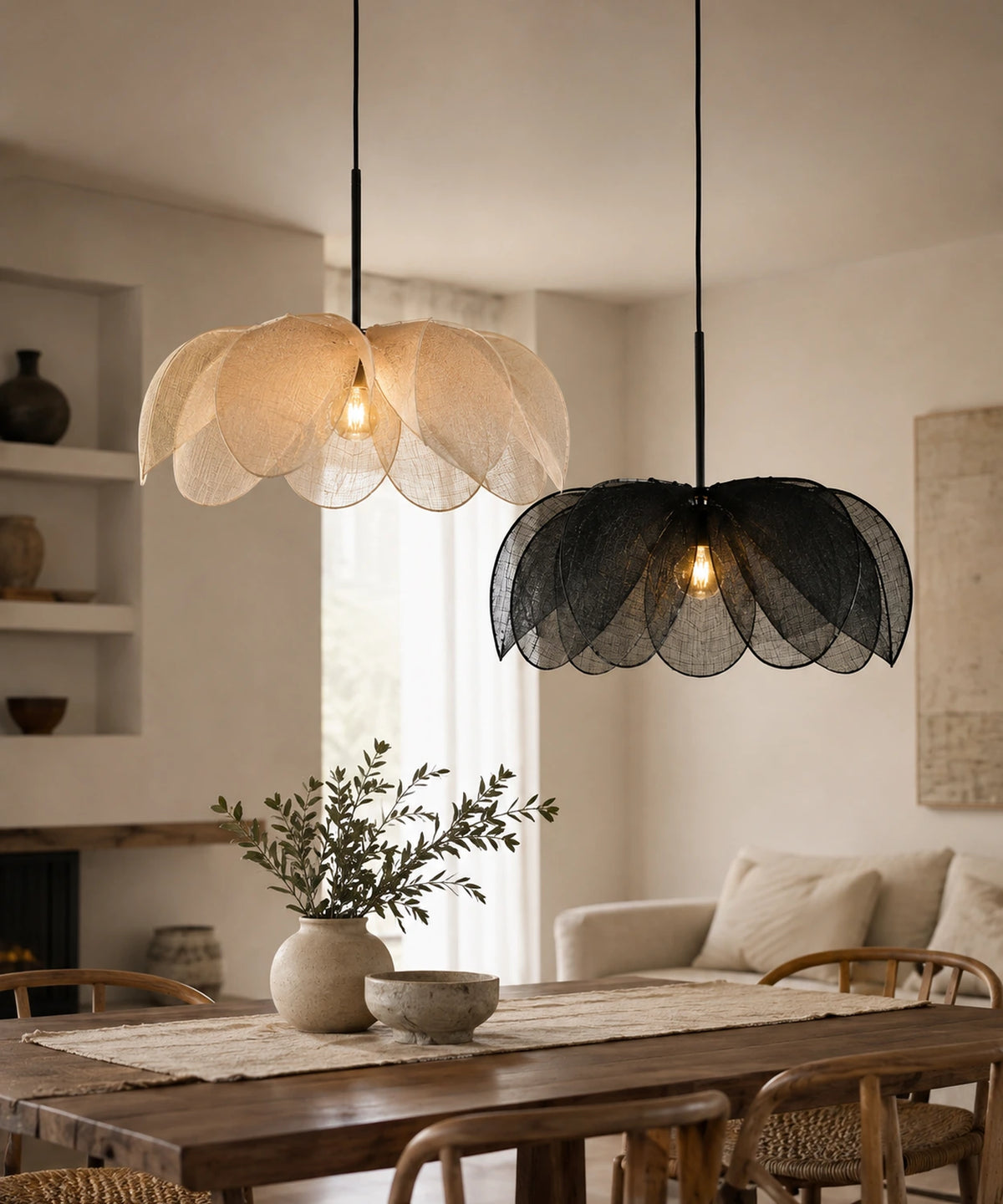 Suspension pétales de tissu, versions écru et noire allumées au-dessus d’une table en bois