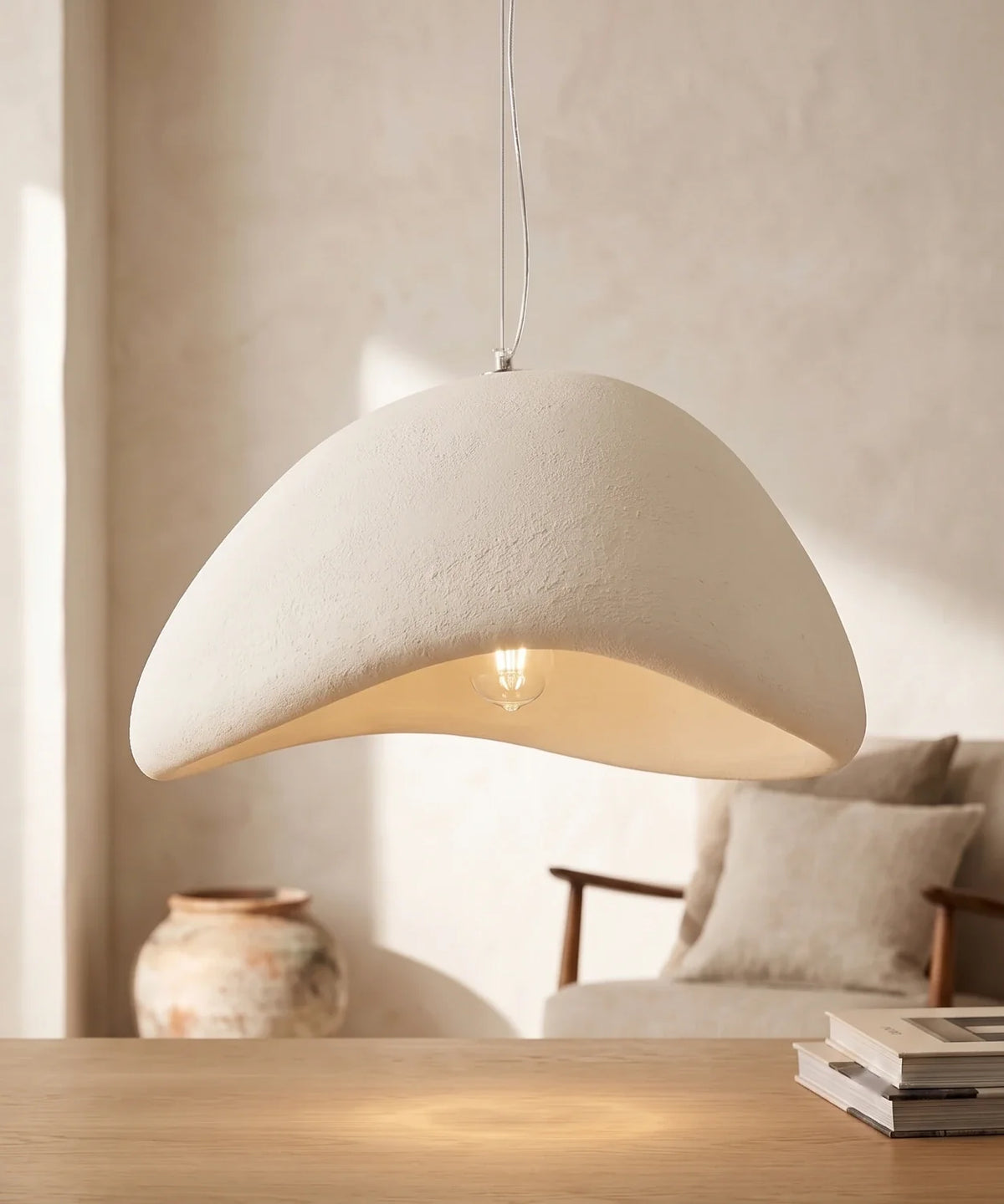 Suspension wabi sabi galet blanche coque ouverte allumée au-dessus d un chevet en noyer