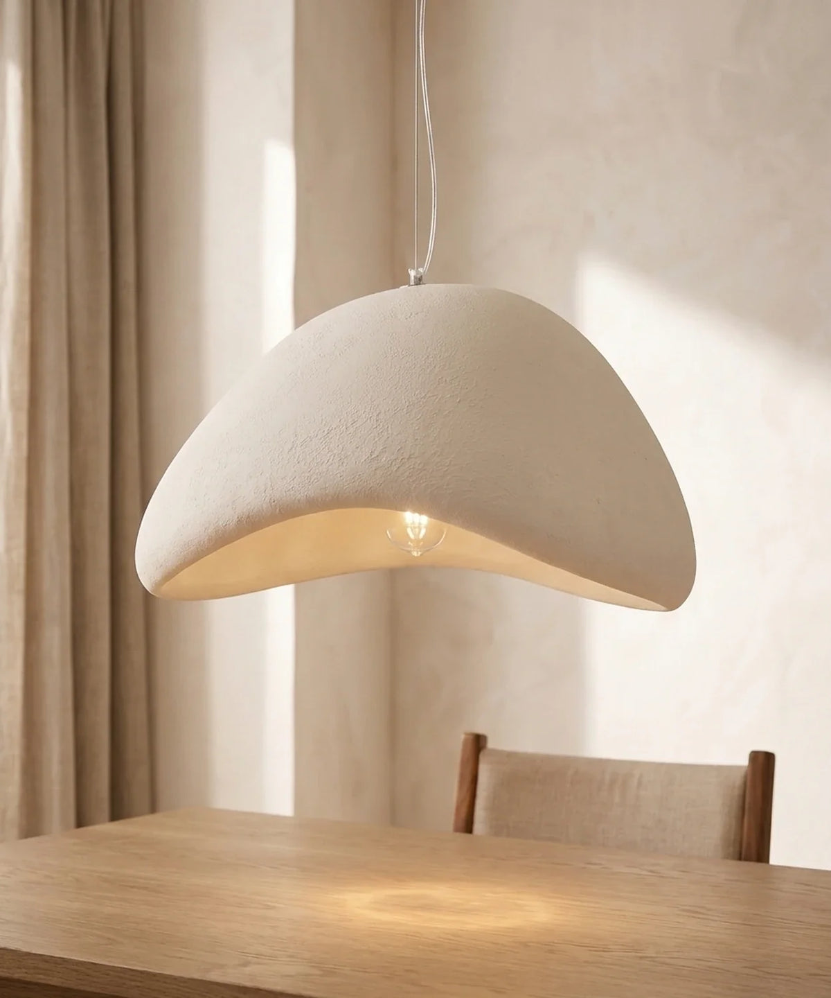 Suspension wabi sabi galet blanche allumée au-dessus d une table en chêne massif